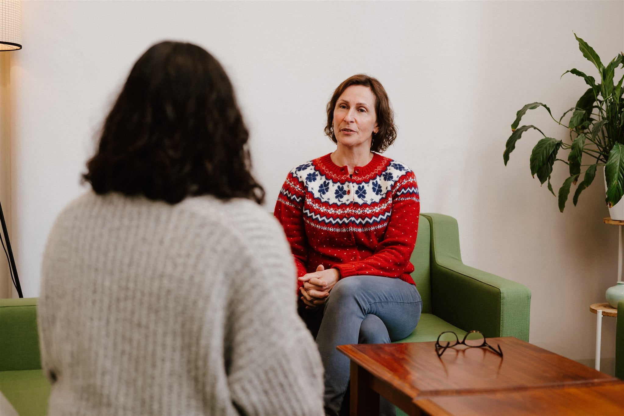 A counsellor is speaking with a participant in a CASA House counselling room. They're sitting opposite from each other on couches.